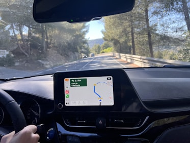 A confident driver checking route details on a digital map inside a vehicle.