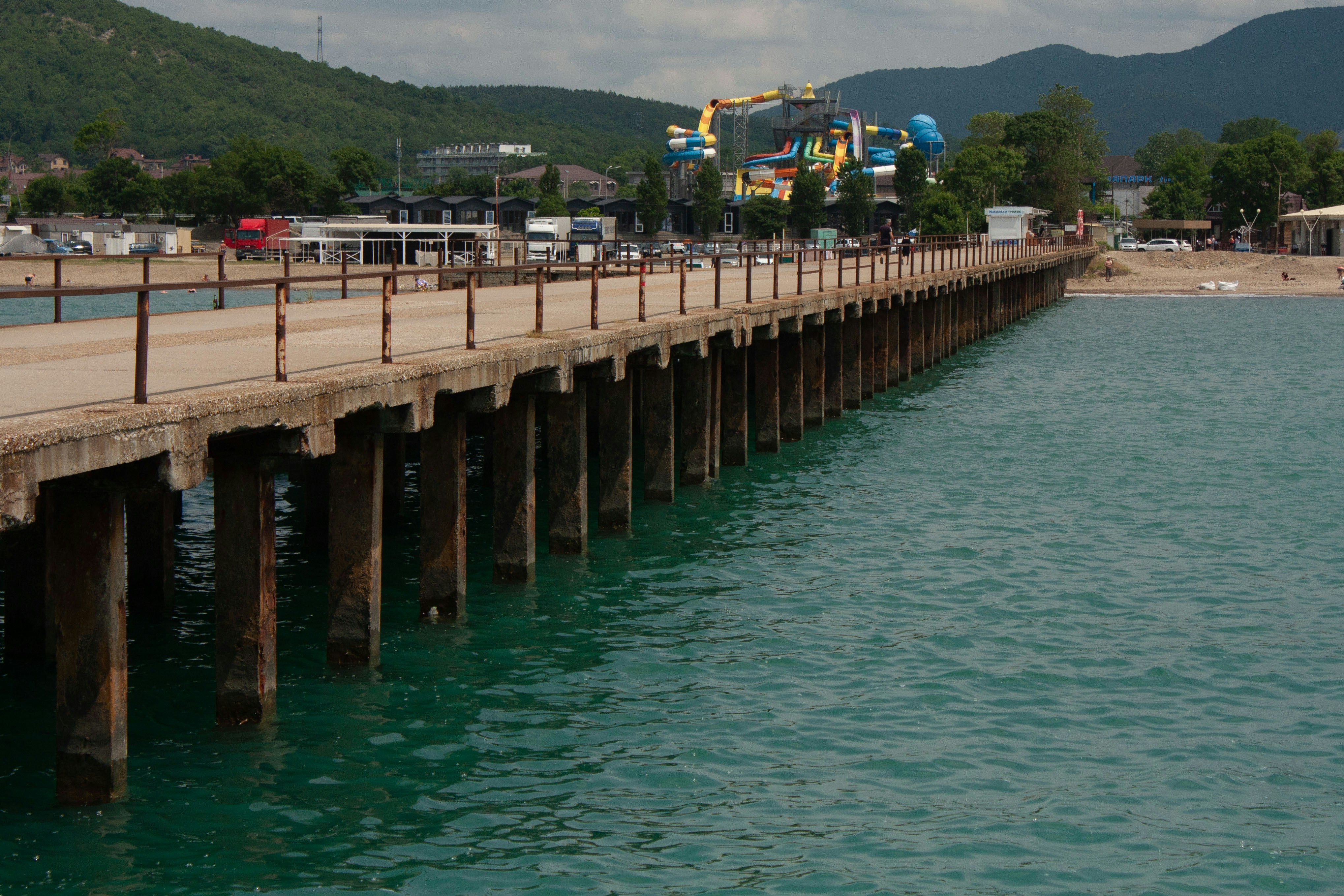 a pier with a roller coaster in the background