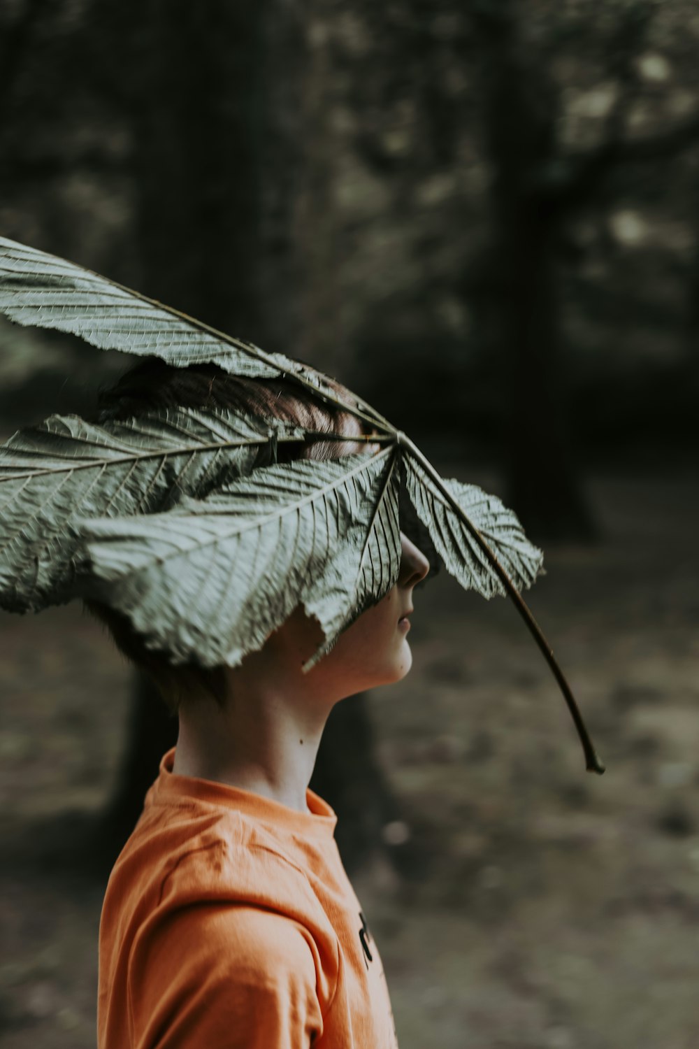 a boy with a leaf on his head
