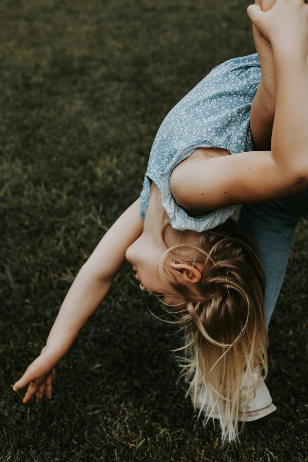 a woman is doing a handstand on the grass