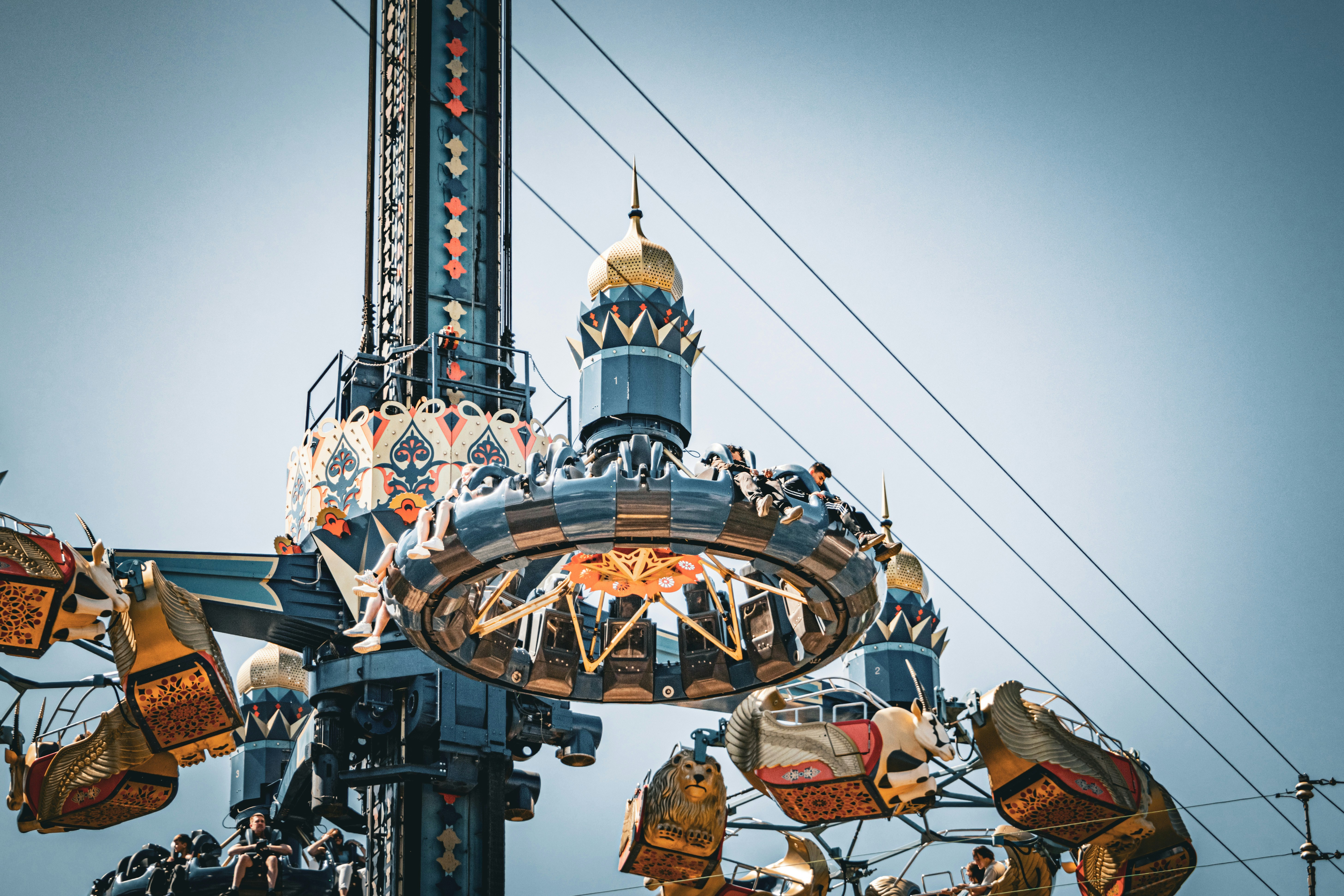 A carnival ride with a clock tower in the background photo – Free ...