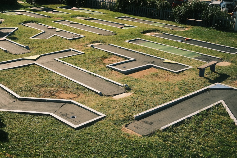 a group of cement benches sitting on top of a lush green field