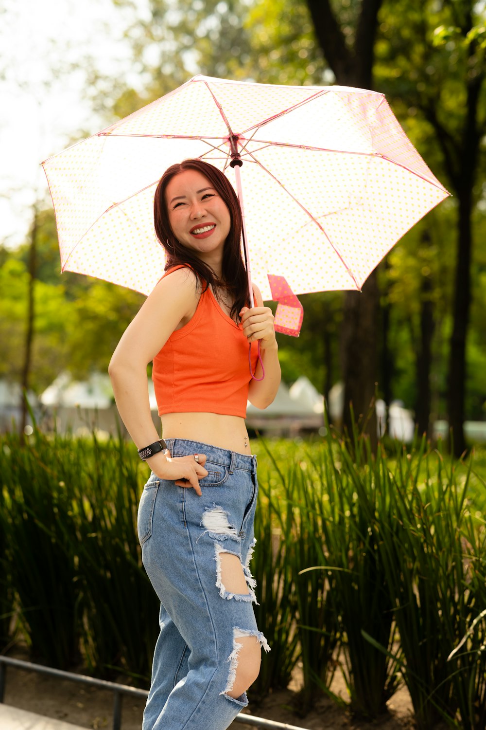 a woman holding an umbrella and posing for a picture