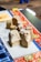 A close-up view of intricately carved wooden stamps with floral designs. These stamps are placed on a table covered with colorful fabric, displaying vibrant patterns such as floral and plaid prints.