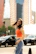 A dynamic outdoor shot of a female model in motion, wearing casual chic attire.