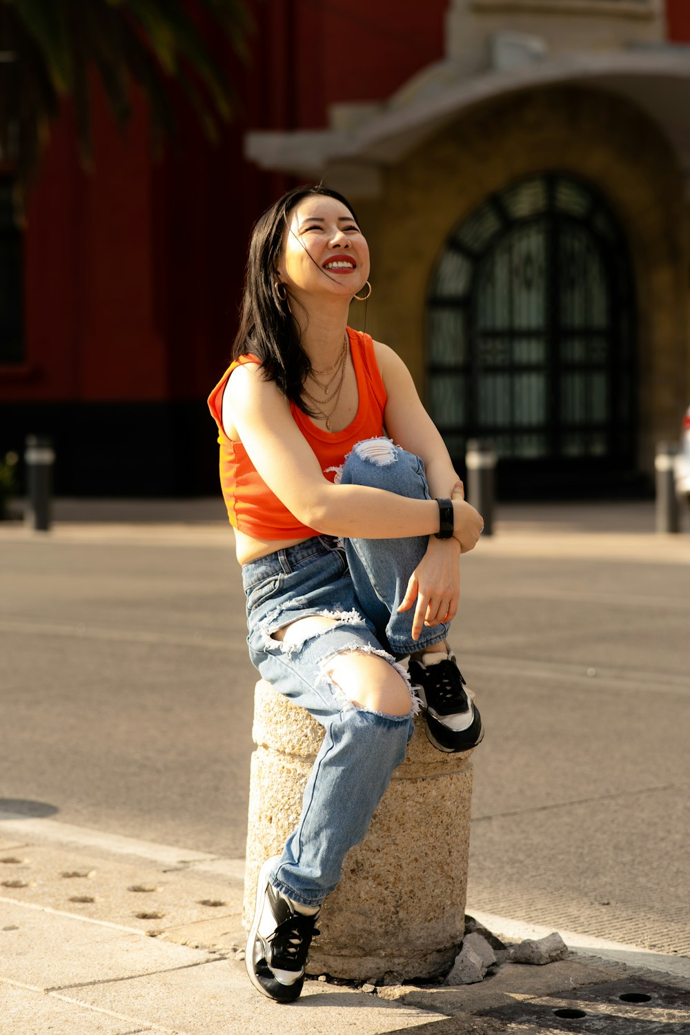 a woman sitting on top of a cement block