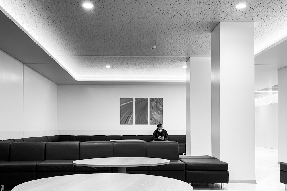 a black and white photo of a person sitting on a couch