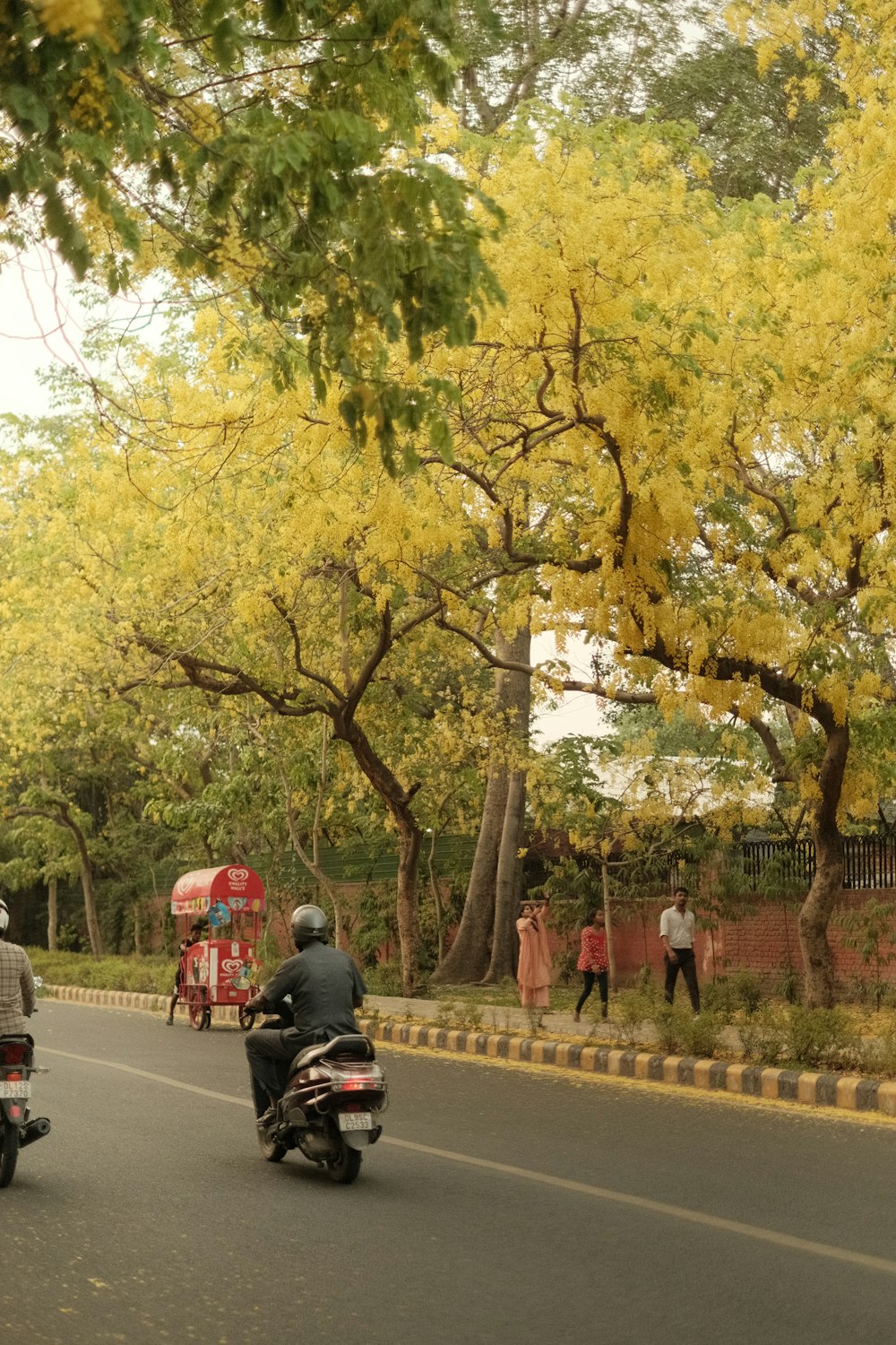 a couple of people riding motorcycles down a street