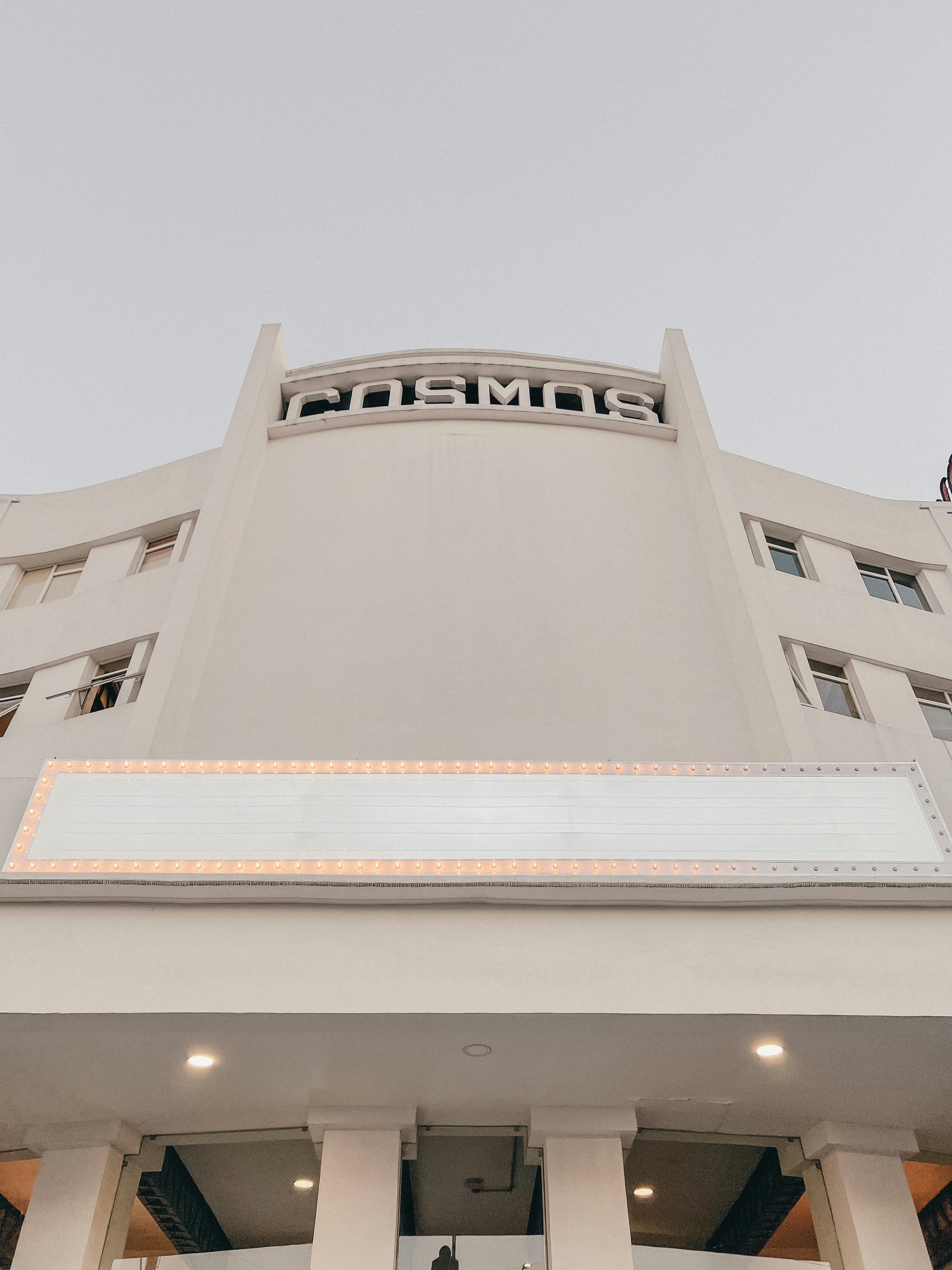 un grand bâtiment blanc surmonté d’un panneau
