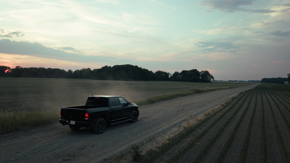 a truck is driving down a dirt road