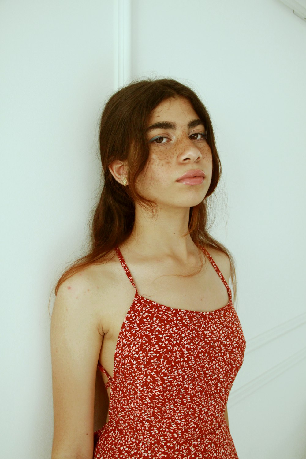 a woman with freckled hair wearing a red dress