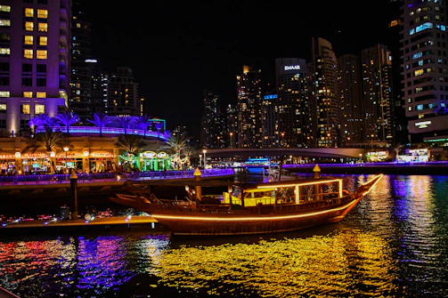 A cozy dinner cruise boat adorned with golden lights sailing along the Goan coastline.