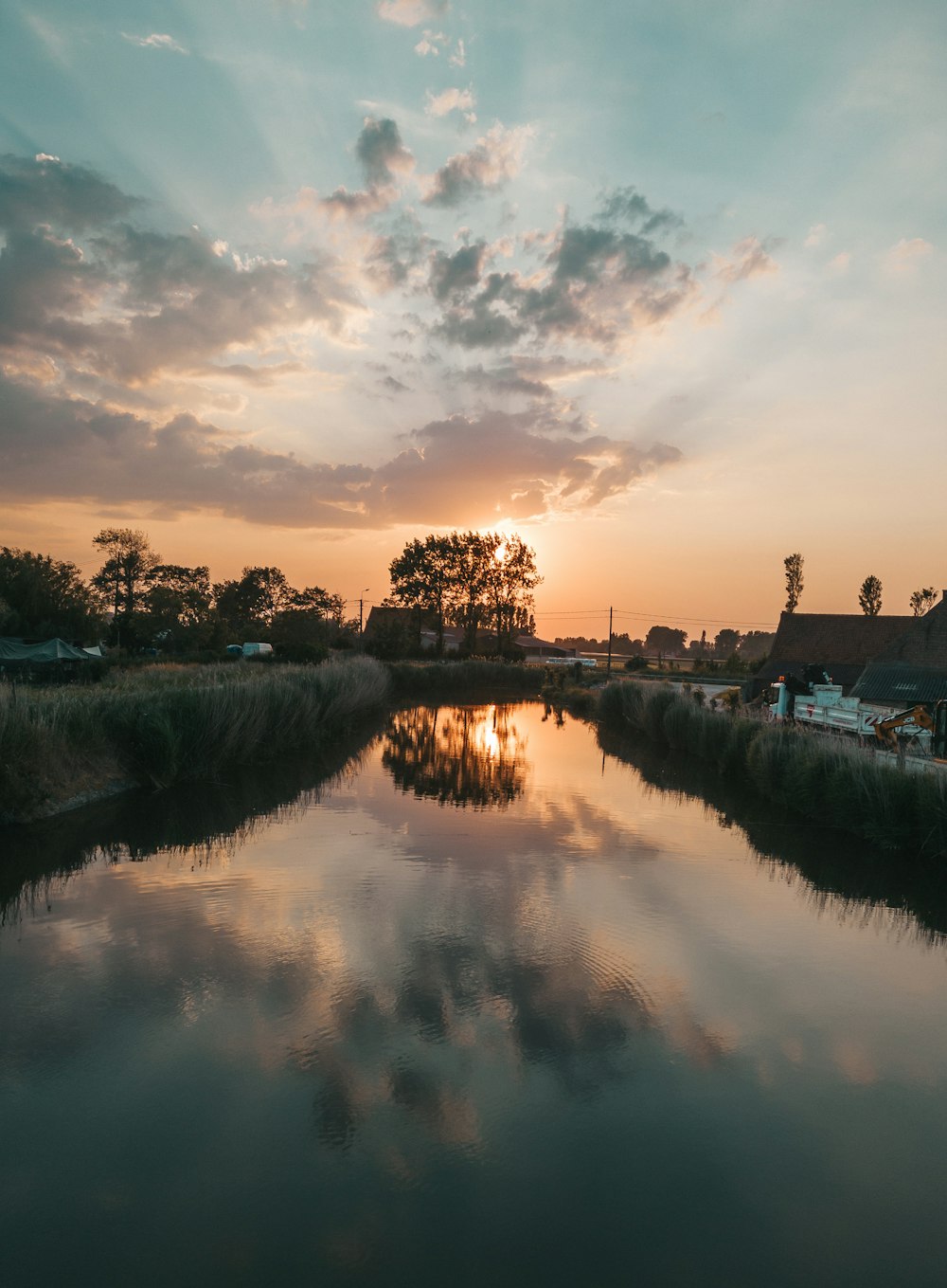 the sun is setting over a small river