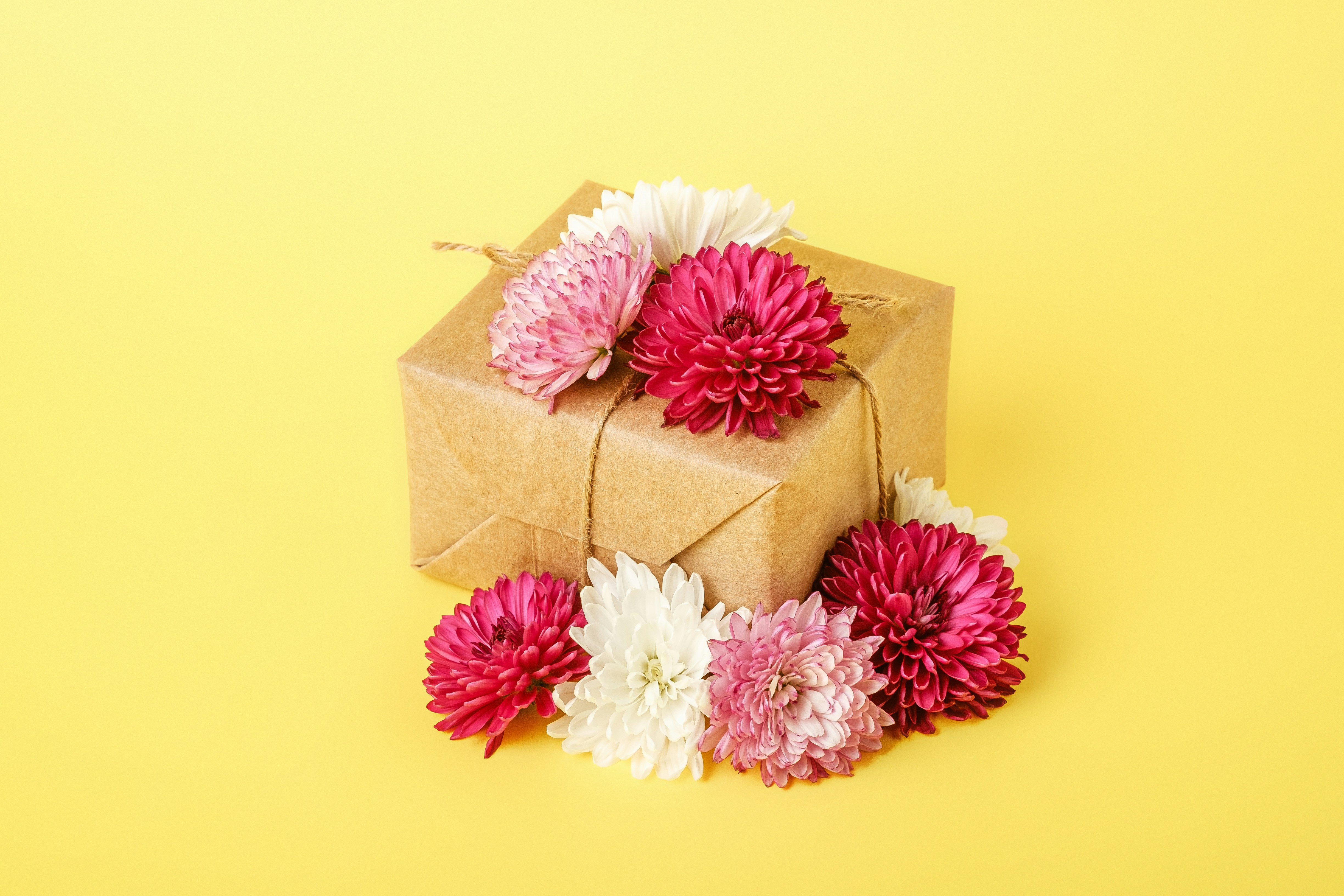 a present box with pink and white flowers on a yellow background