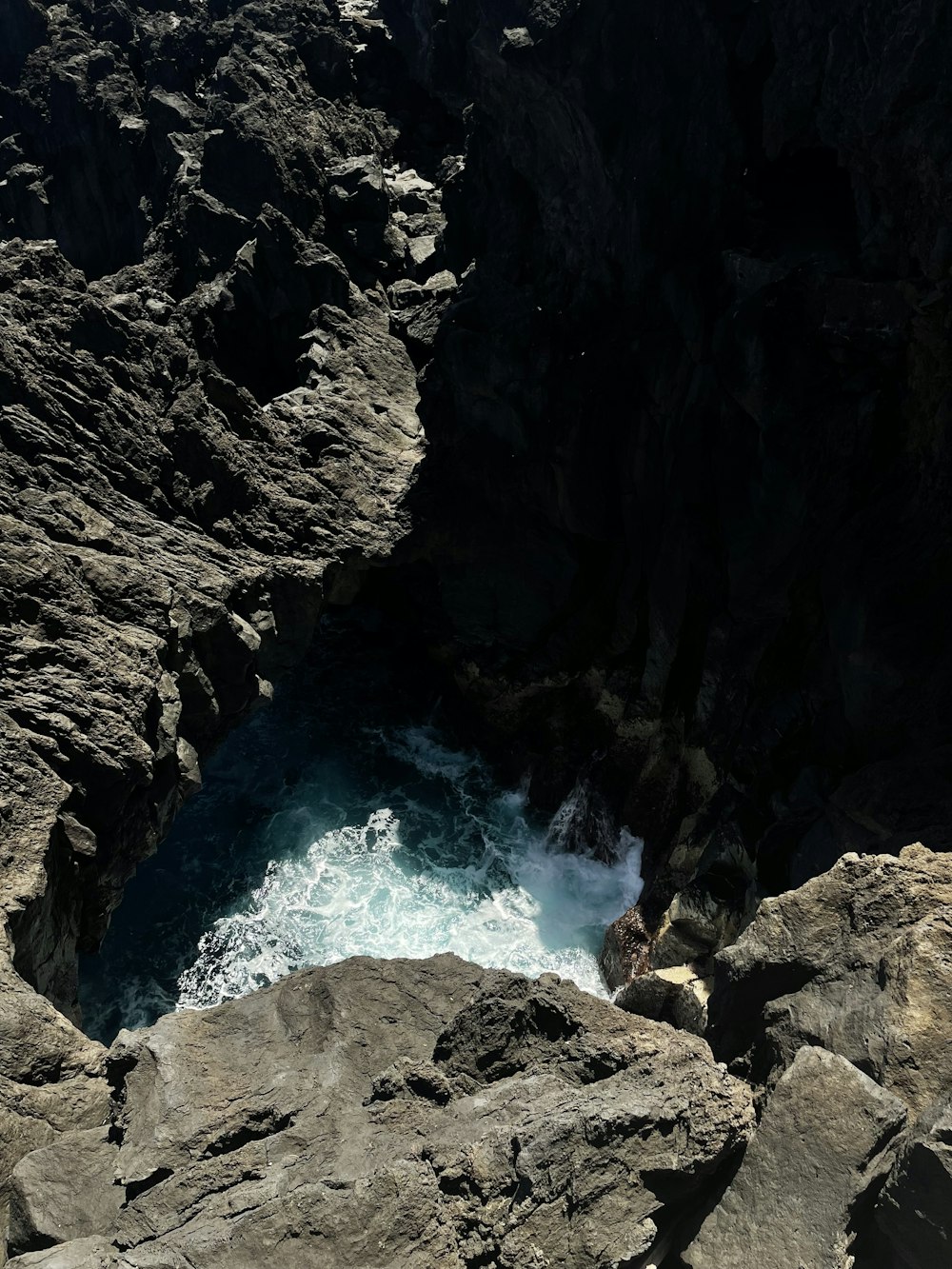 a rocky cliff with a body of water coming out of it