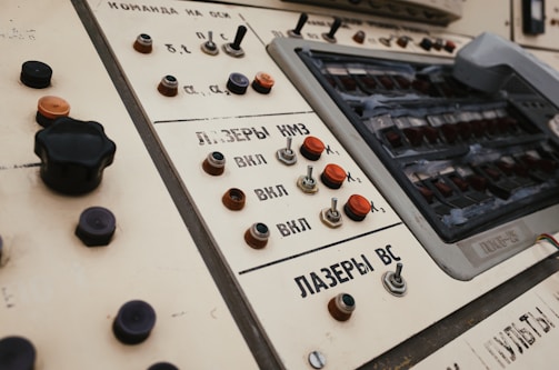 Control panel featuring various buttons, switches, and dials. The panel includes text in Cyrillic script and appears vintage, with wear visible on some components.