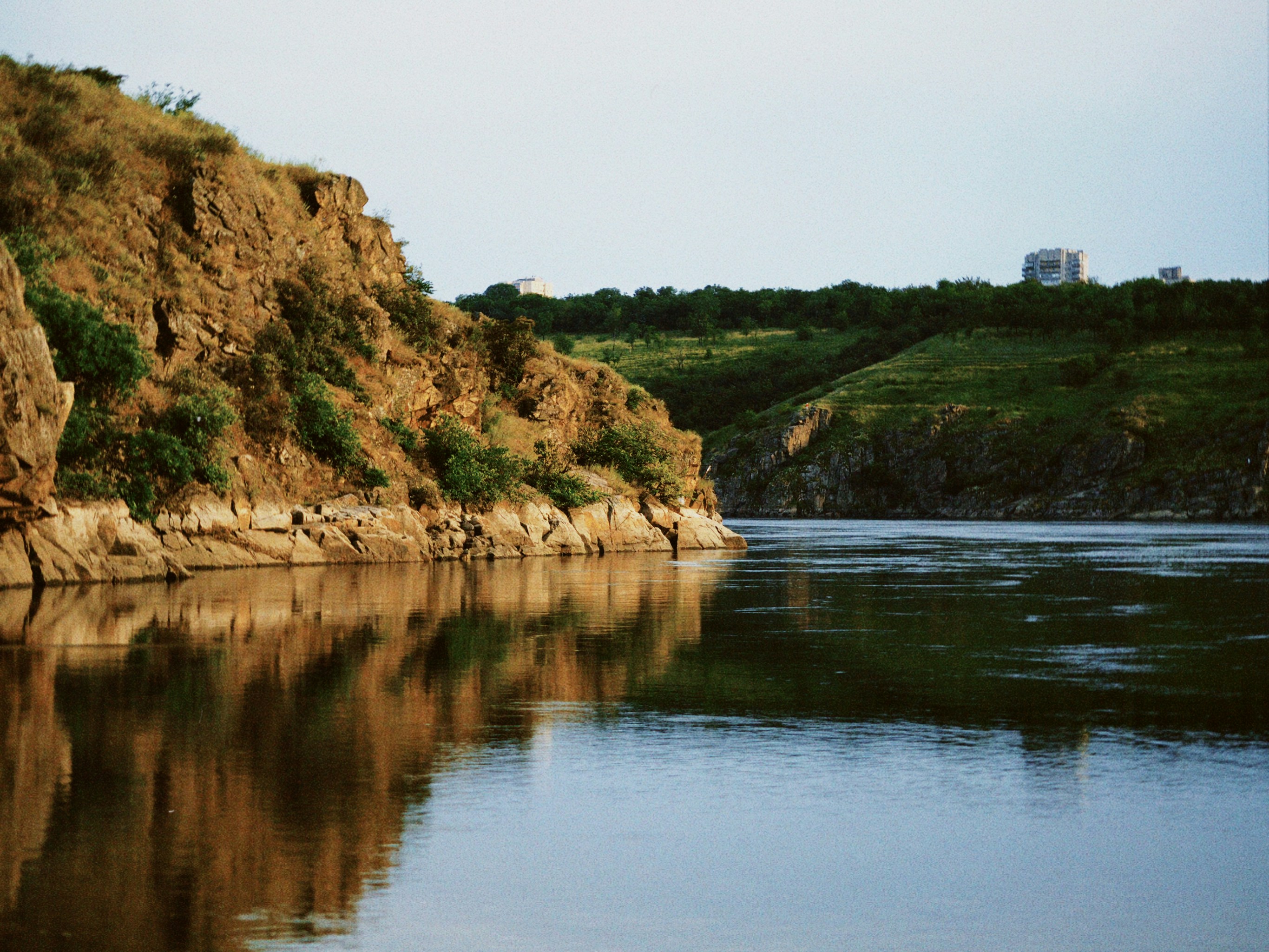 a body of water with a hill in the background