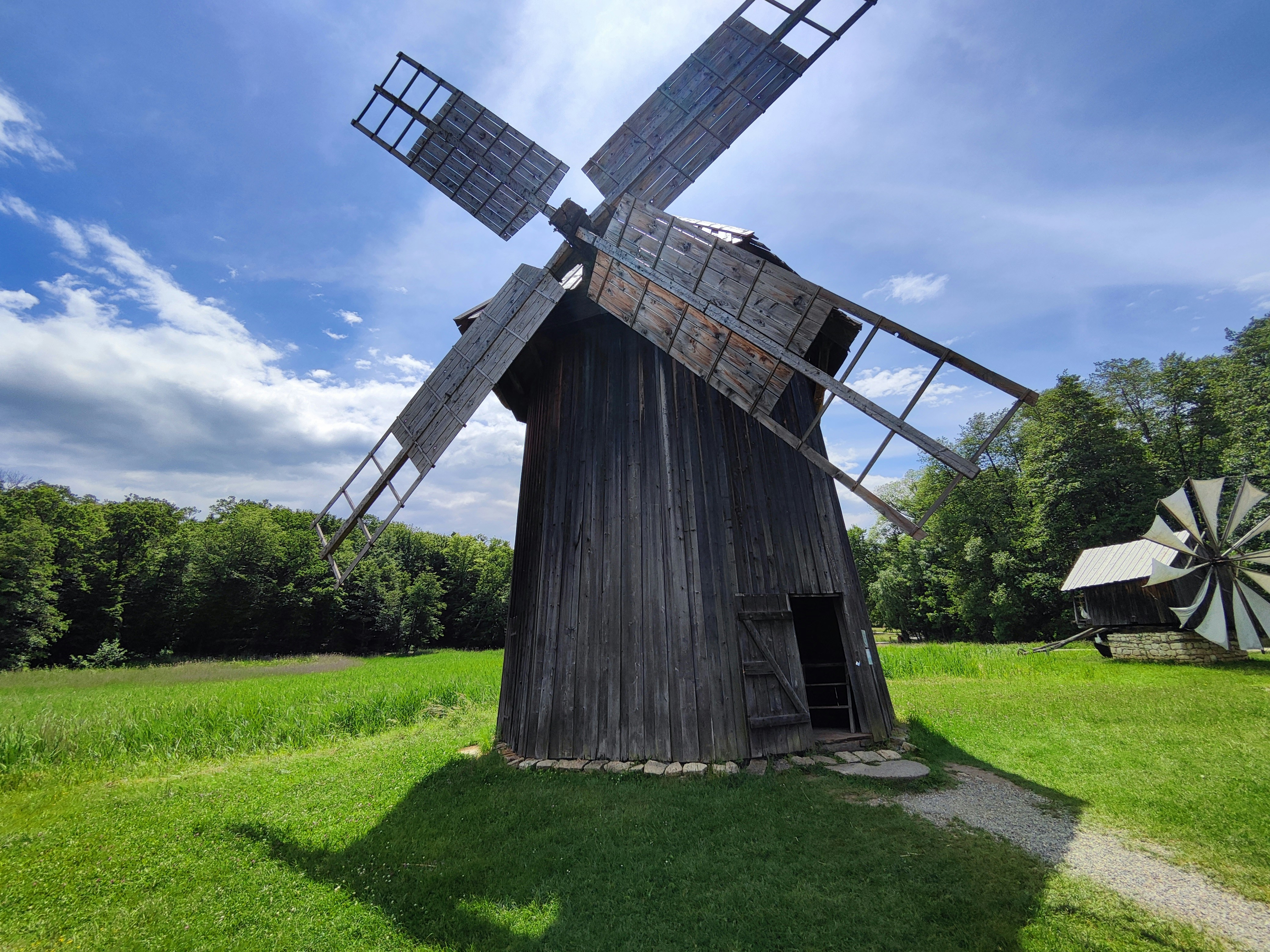 a windmill in the middle of a grassy field