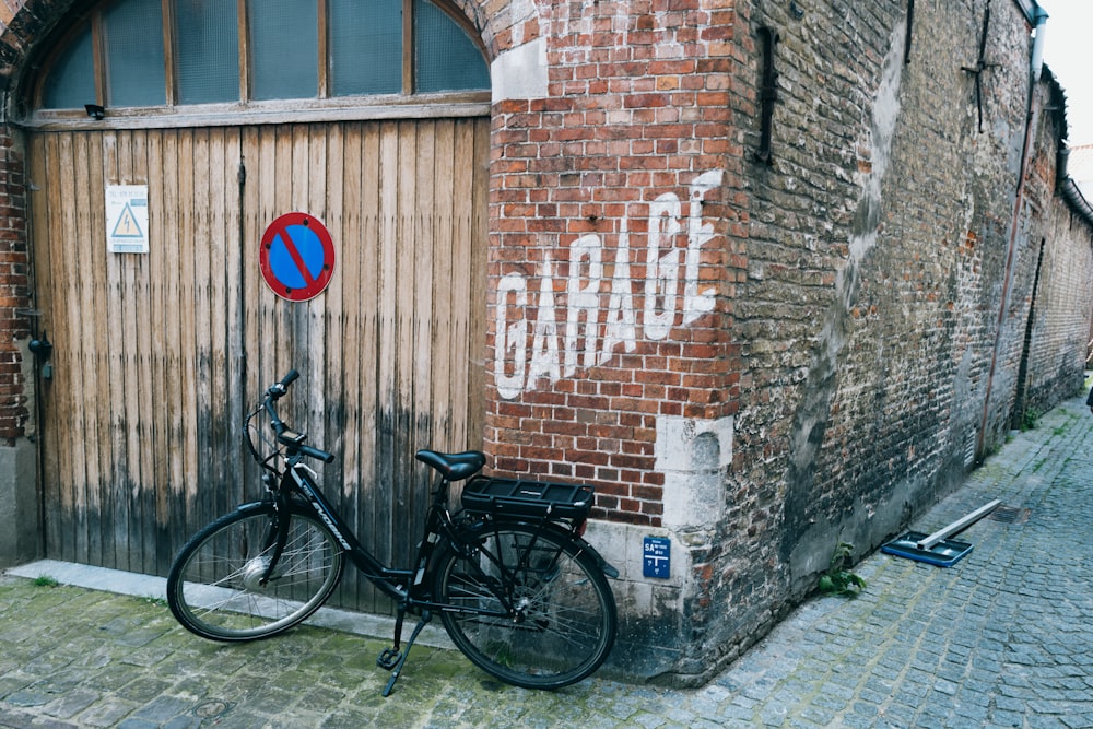 a bicycle parked next to a brick building