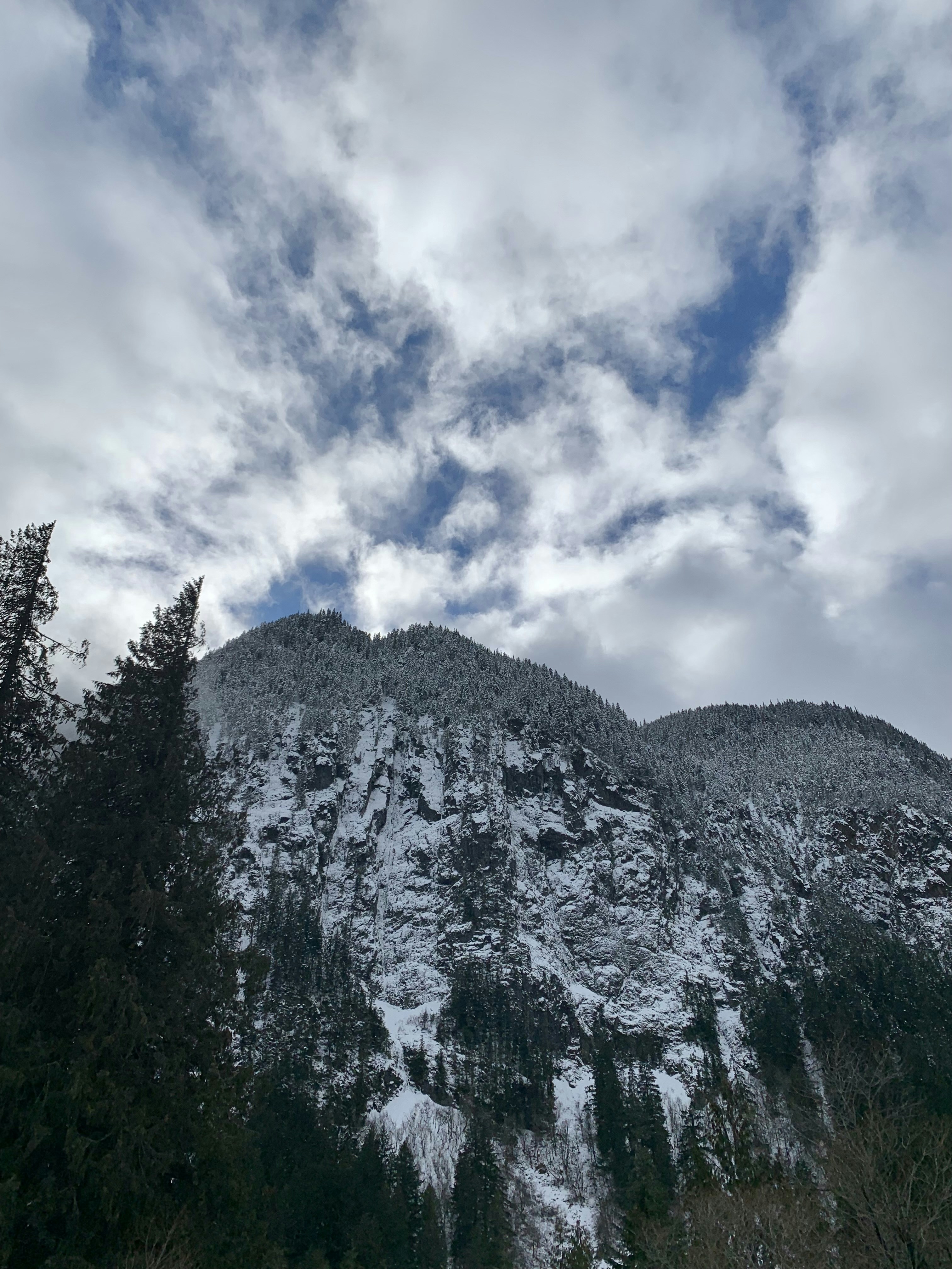 a snow covered mountain under a cloudy sky