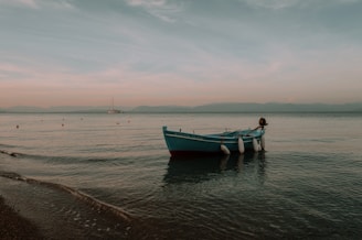 A center console boat anchored peacefully with a backdrop of a pastel-colored sky at dusk.