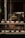 A bakery display window featuring an assortment of pastries and bread. The shelves are lined with various baked goods like croissants, muffins, and loaves, each accompanied by small name cards. The display is warmly lit, creating a cozy and inviting atmosphere.