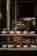 A small bakery storefront with a welcoming sign and fresh pastries displayed in the window.