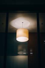 Modern wooden pendant light casting warm glow in a sleek, minimalist living room.