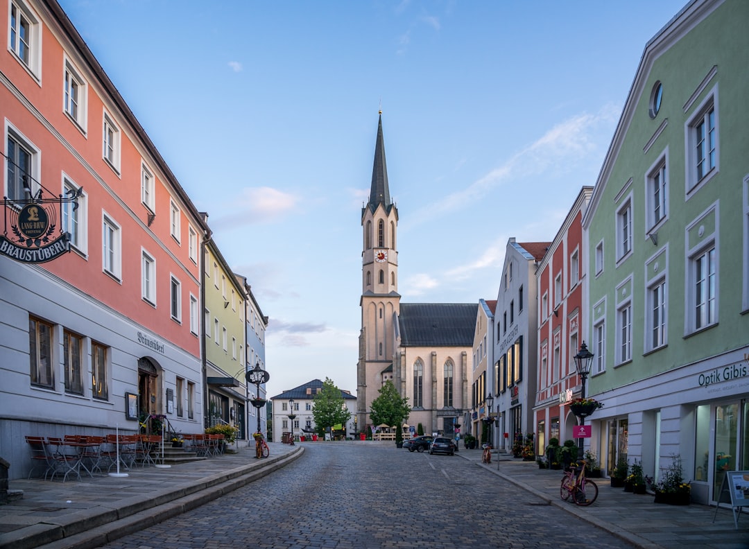a cobblestone street with a church steeple in the background,