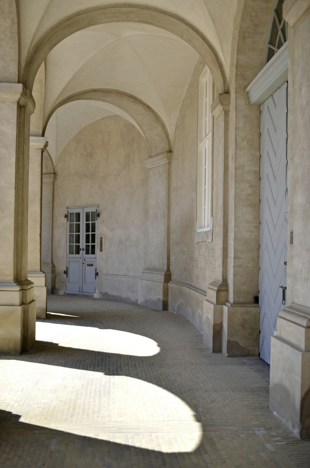 a long hallway with a door and windows