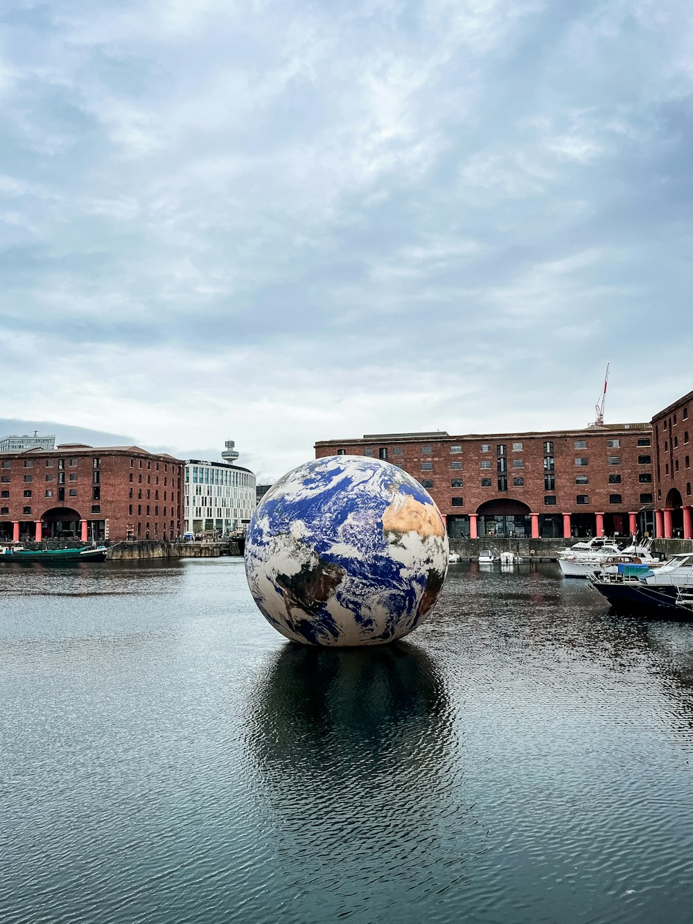 a large blue and white ball sitting on top of a body of water