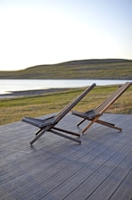 a couple of lawn chairs sitting on top of a wooden deck