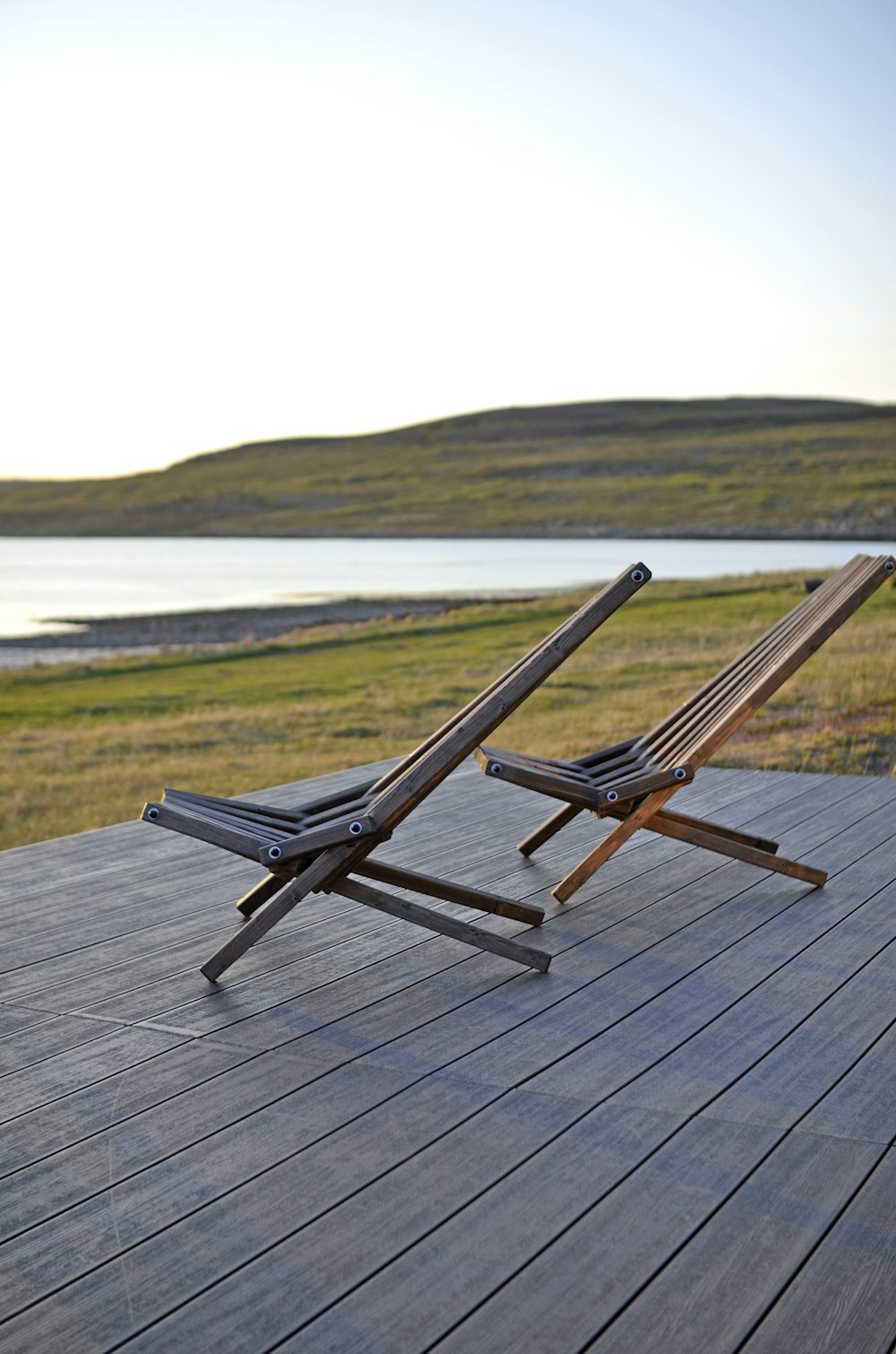 a couple of lawn chairs sitting on top of a wooden deck
