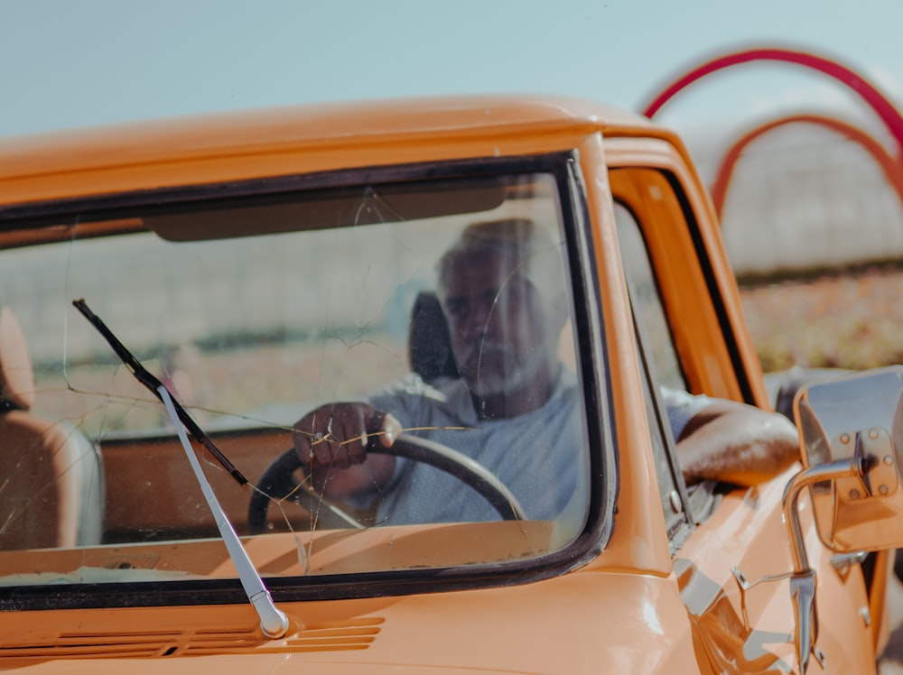 a man driving a truck with a steering wheel