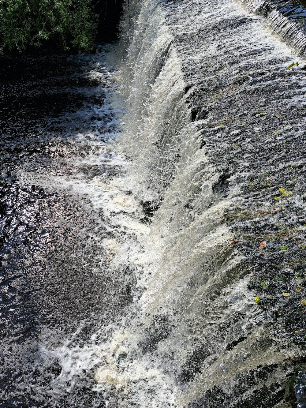 a man is standing on the edge of a waterfall