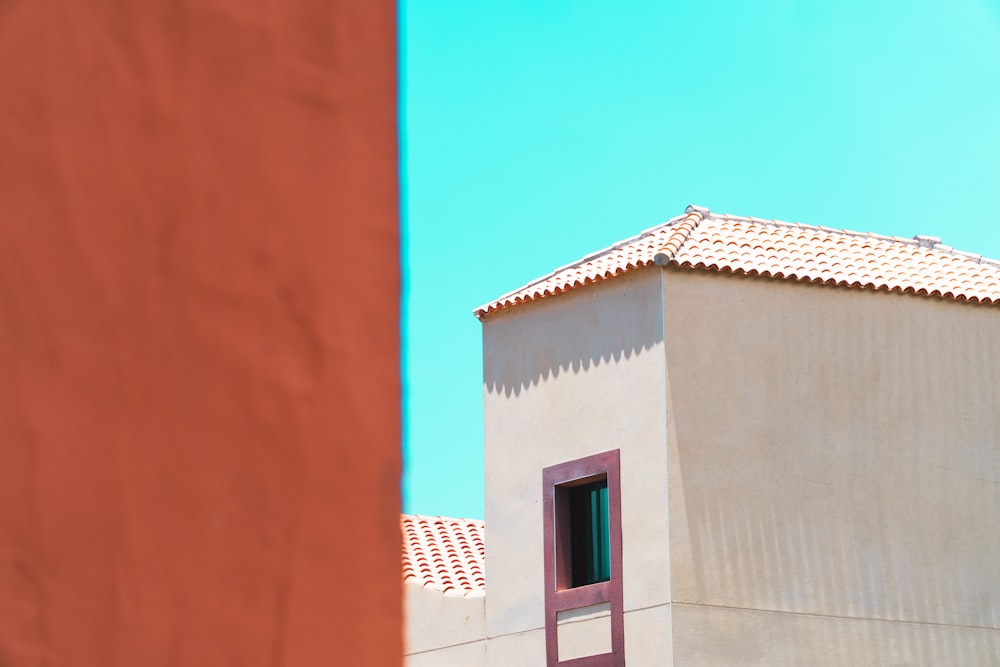 a tall building with a red window and a sky background