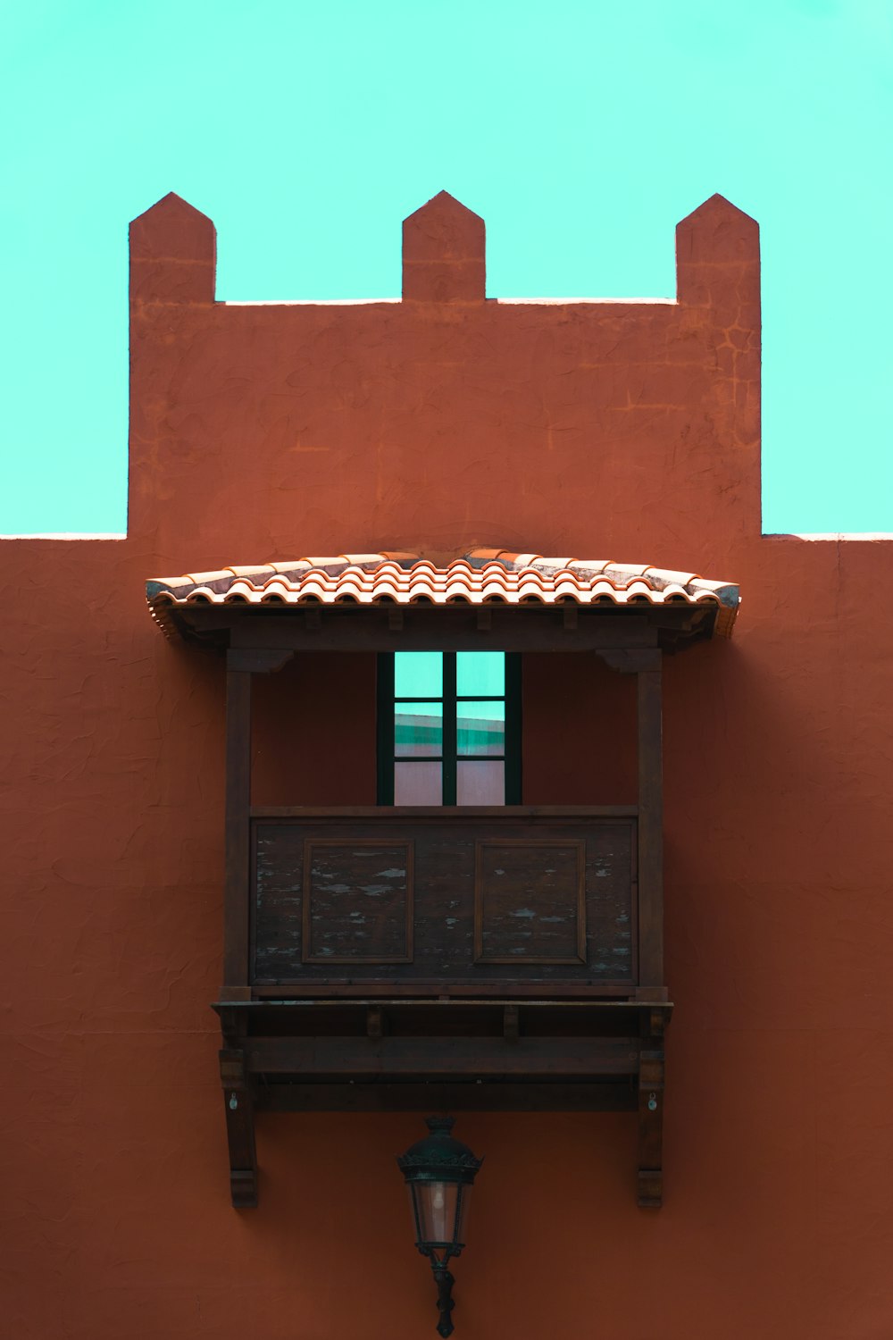 a red building with a balcony and a lamp