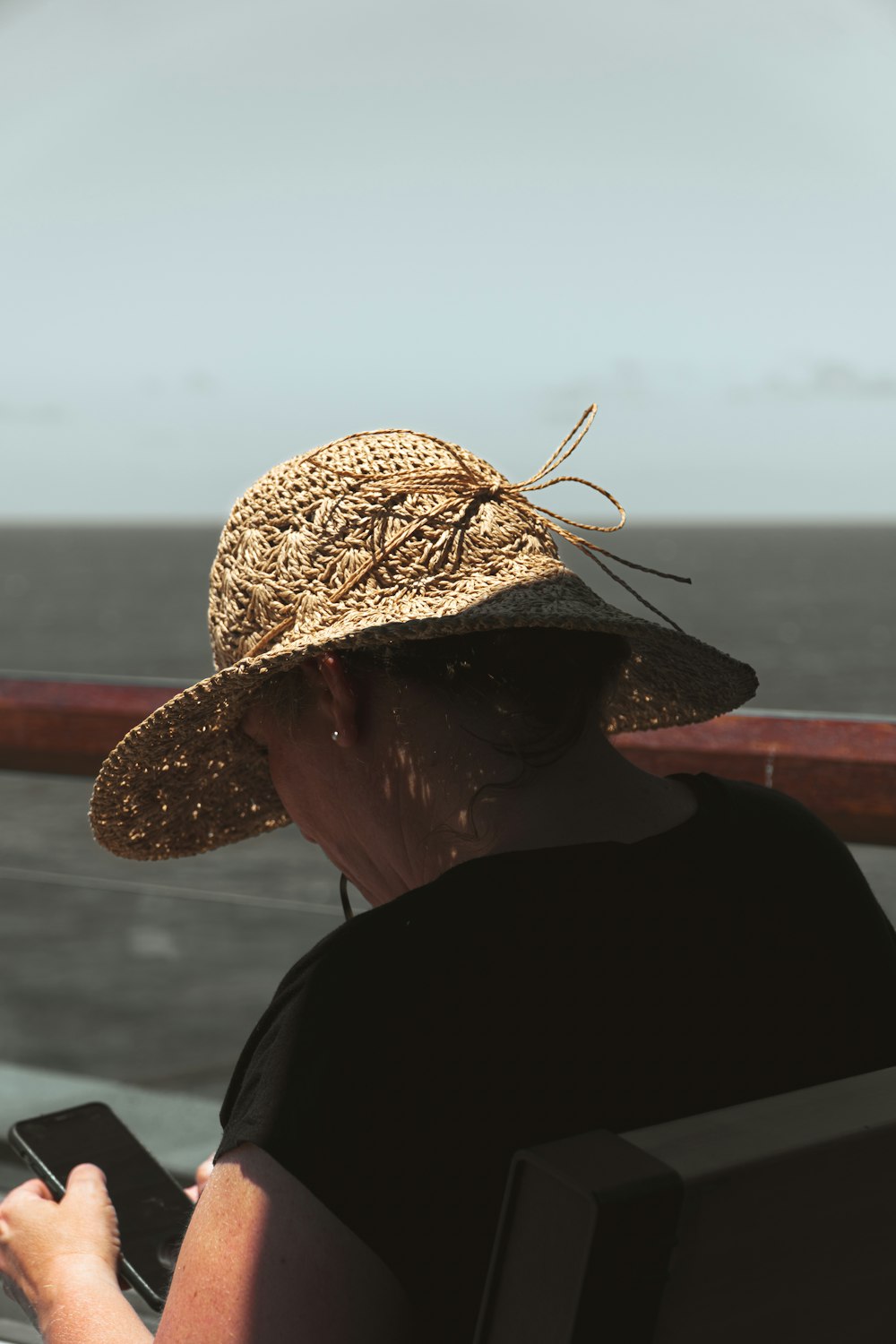 a woman sitting on a boat looking at her cell phone