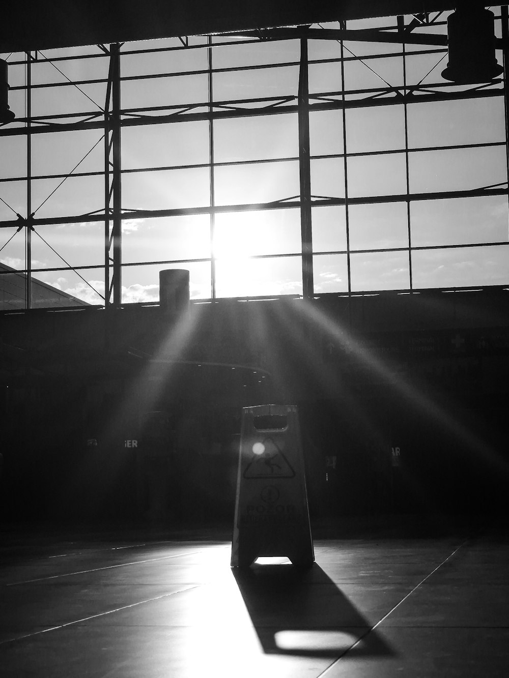 a black and white photo of the sun shining through a window