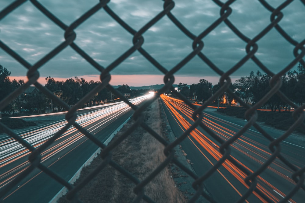 a view of a highway through a chain link fence