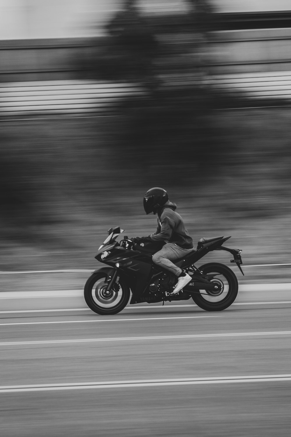 a black and white photo of a person riding a motorcycle