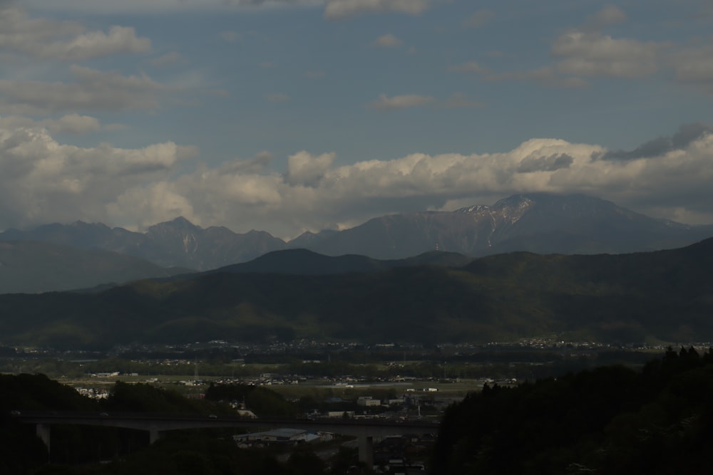 a view of a mountain range with a bridge in the foreground