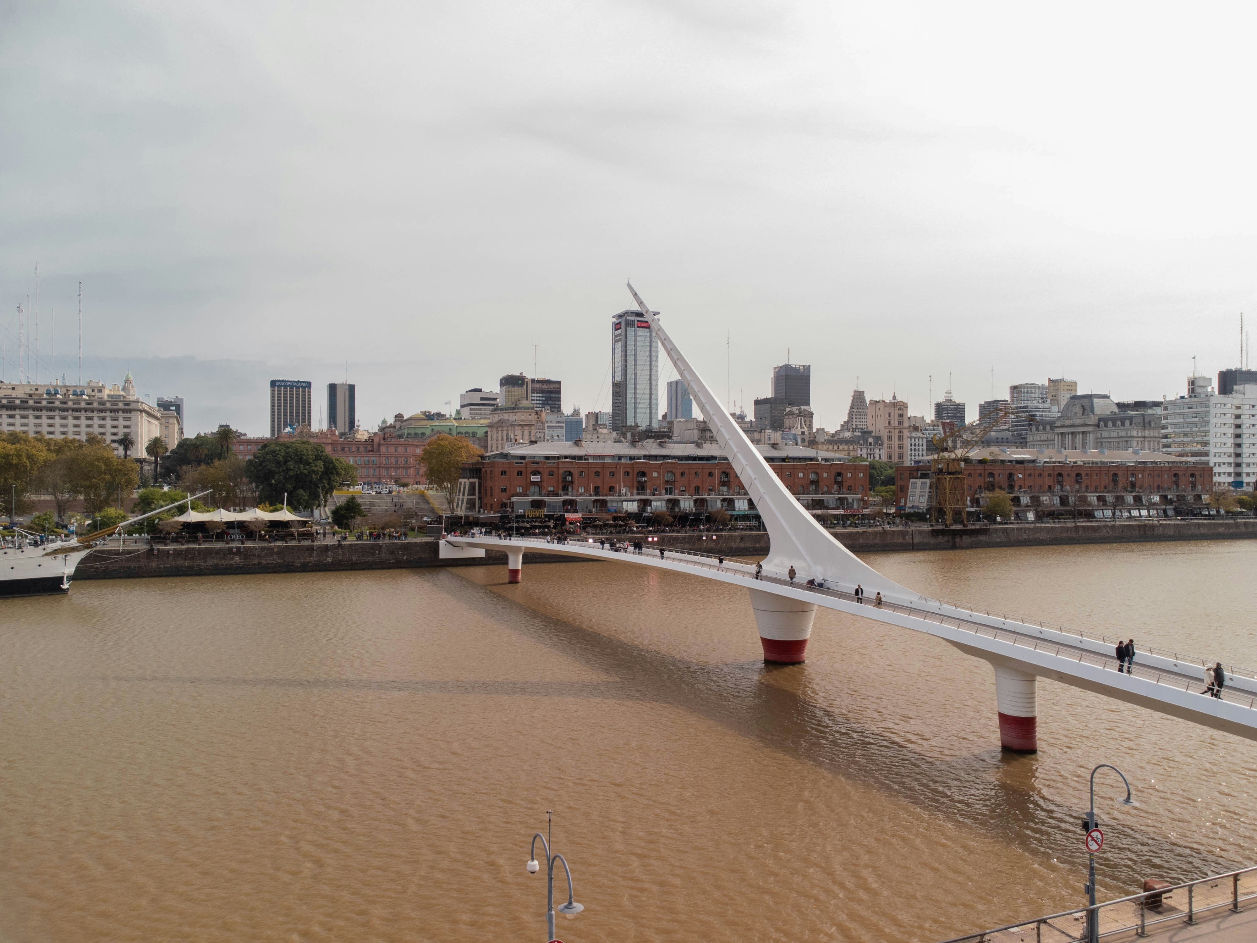 a bridge over a body of water with a city in the background
