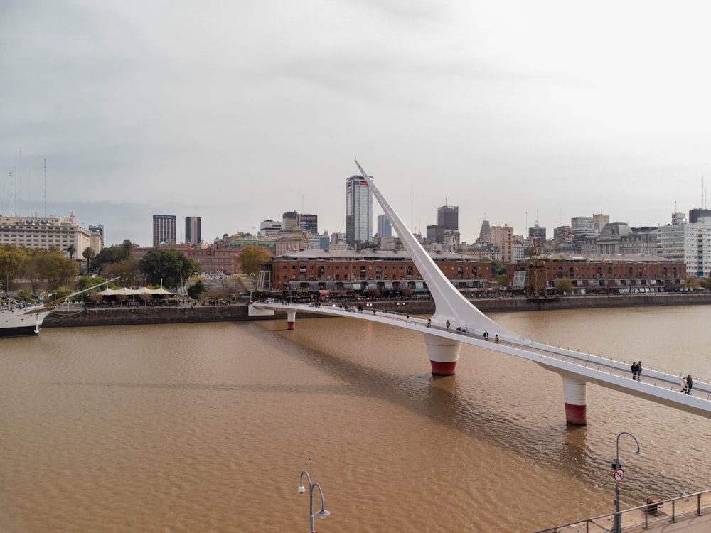 un pont sur un plan d’eau avec une ville en arrière-plan