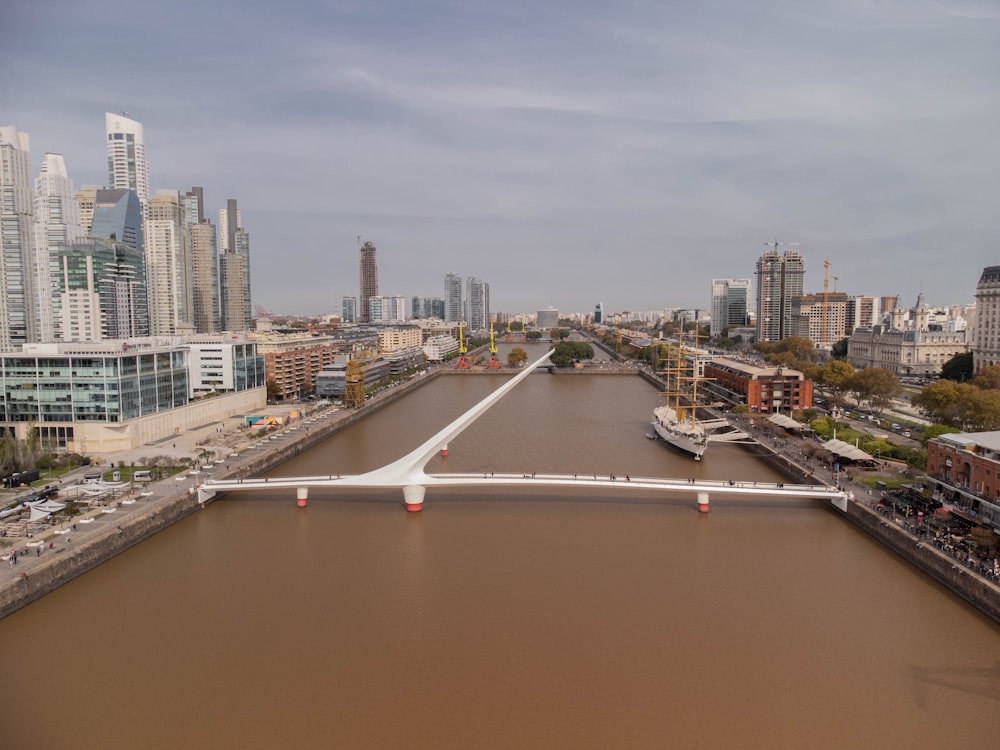 an aerial view of a river with a bridge in the middle