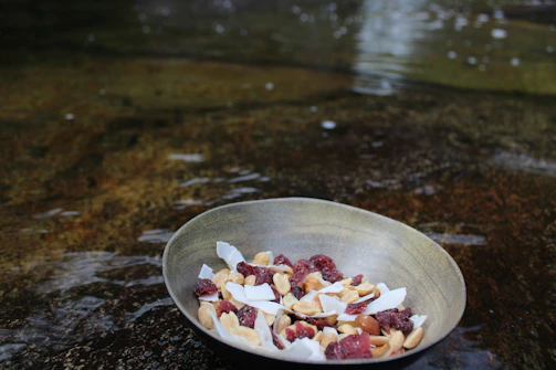 Minimalist display of mixed dry fruits in a rustic bowl, set against a clean white backdrop.