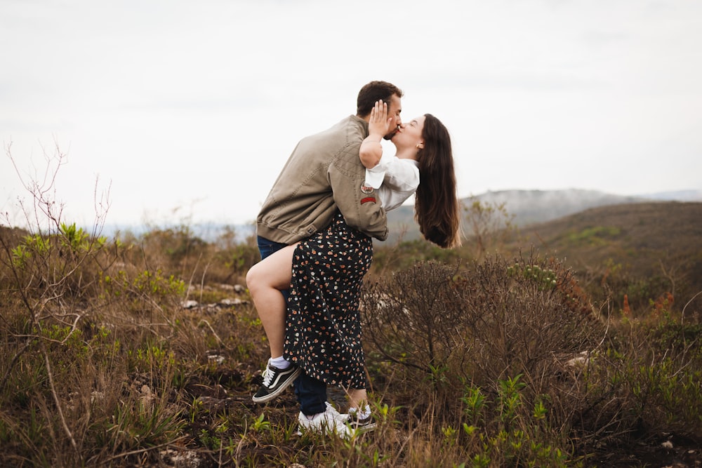 a man and a woman kissing in a field