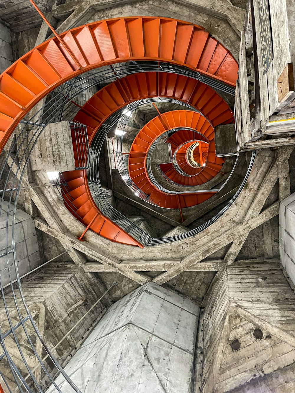 a spiral staircase in a building with orange railings