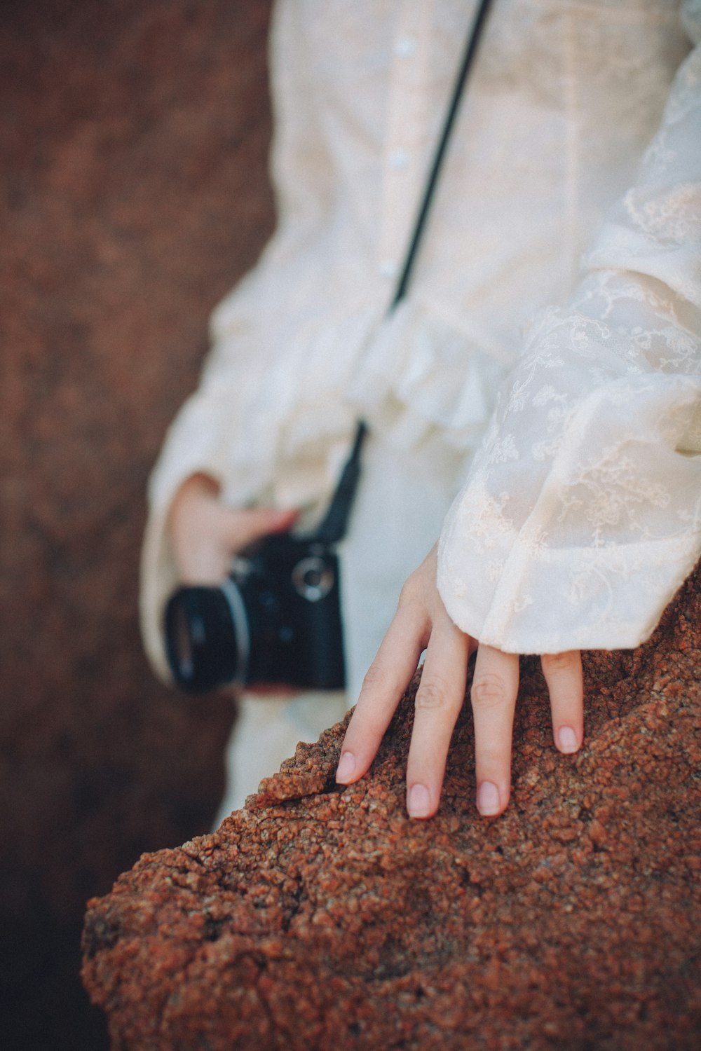 a person with their hand on a rock