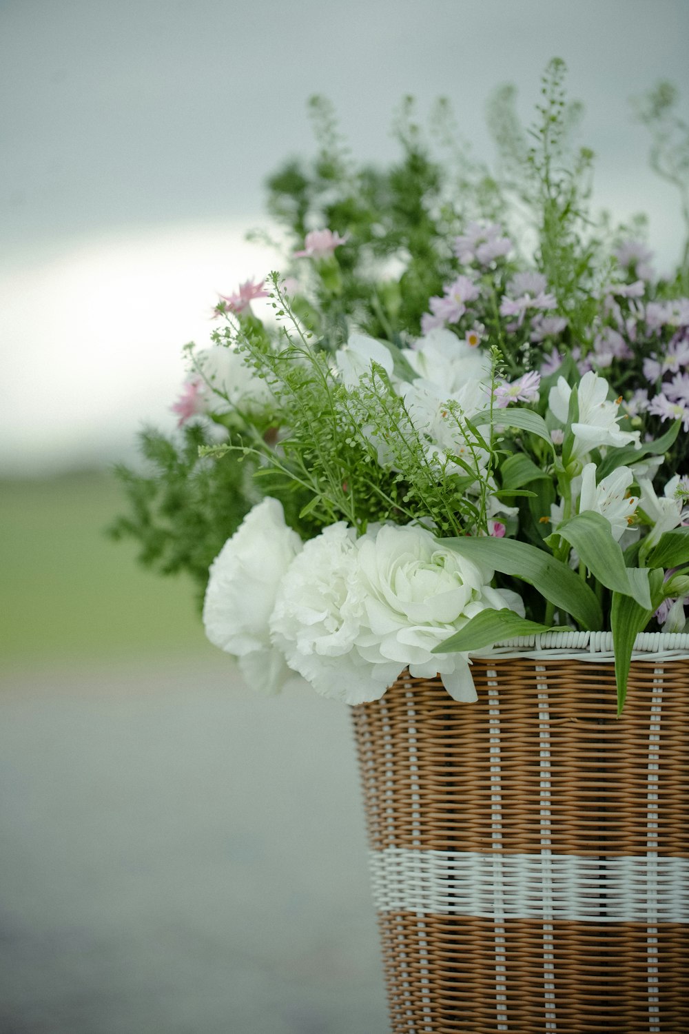 a basket filled with lots of white and purple flowers